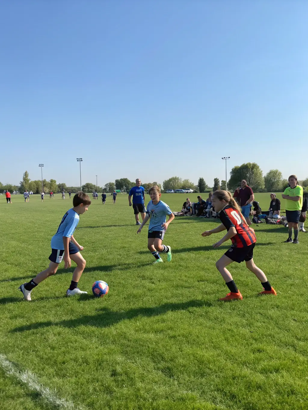 A photo of teenage players engaged in a competitive football match organized by FCBO FCB Les Olives, emphasizing skill and strategy.